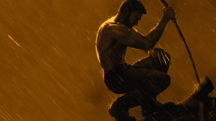 A dramatic HD wallpaper from the movie The Wolverine, featuring the character in a crouched position, muscles highlighted against a moody, rain-soaked background.