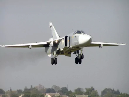 HD desktop wallpaper featuring a close-up of a military aircraft in flight, showcasing its landing gear and wings against a clear sky background.