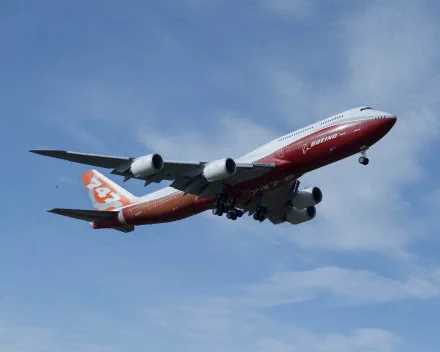 HD PC desktop wallpaper showing a Boeing 747-8 aircraft in flight against a clear blue sky.