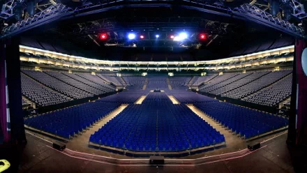 Panoramic interior of The O2 Arena stadium with rows of blue seats and stage lighting, a sports venue shown as an HD PC desktop wallpaper and background.