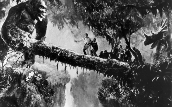 A dramatic scene from King Kong (1933), featuring the giant ape looming over a log, with explorers navigating the treacherous landscape, set against a lush, jungle backdrop.