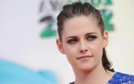 HD desktop wallpaper featuring celebrity Kristen Stewart at an event, looking off-camera with a subtle smile, against a blurred backdrop.