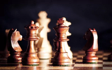 HD PC desktop wallpaper featuring a close-up of man-made chess pieces on a board, highlighting the intricate details of the game in dramatic lighting.
