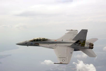 A Boeing F/A-18E/F Super Hornet flies above the clouds, showcasing its sleek military design in this stunning 4K Ultra HD wallpaper.
