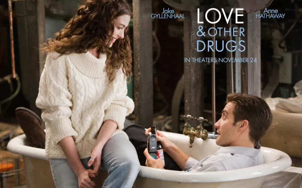 HD desktop wallpaper featuring Jake Gyllenhaal and Anne Hathaway in a romantic scene from the movie Love & Other Drugs, with the film's title and release date displayed.