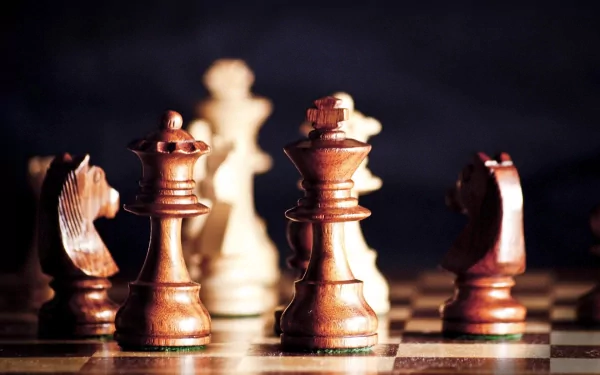 HD PC desktop wallpaper featuring a close-up of man-made chess pieces on a board, highlighting the intricate details of the game in dramatic lighting.