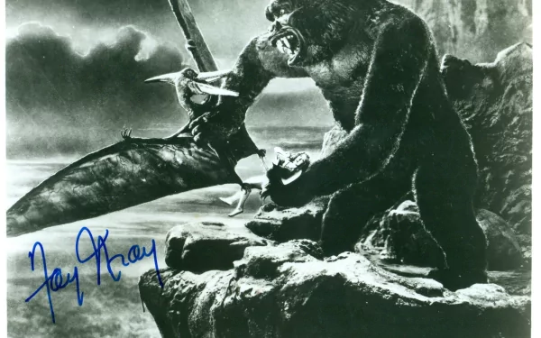 A dynamic scene from the classic 1933 film King Kong, featuring the iconic giant ape in a dramatic confrontation on a rocky shore, captured in a stunning black-and-white HD wallpaper.