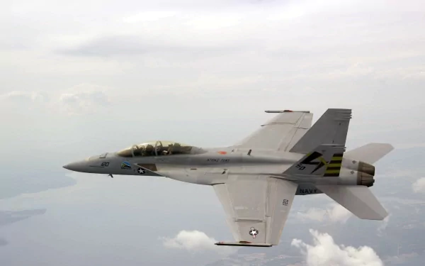 A Boeing F/A-18E/F Super Hornet flies above the clouds, showcasing its sleek military design in this stunning 4K Ultra HD wallpaper.