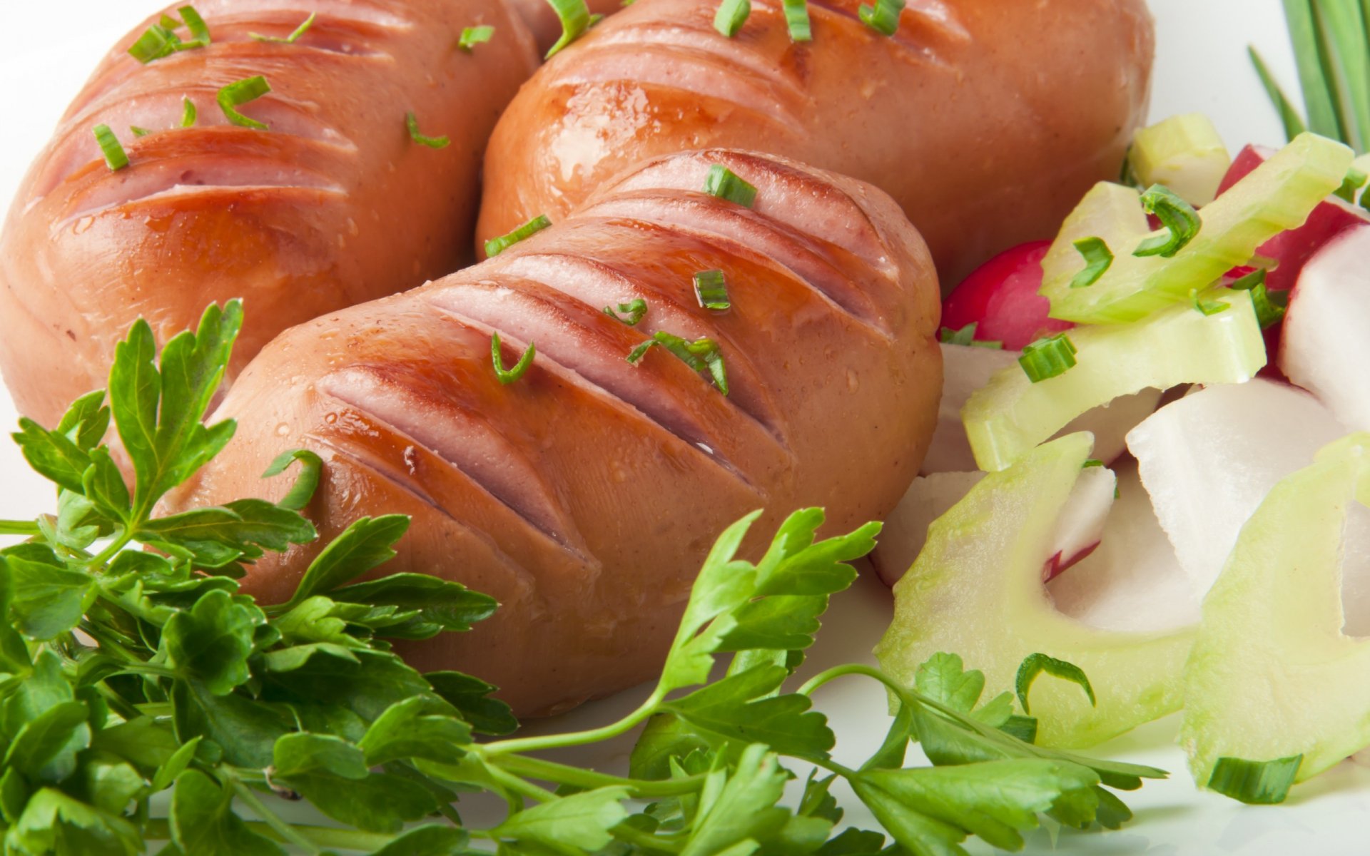 HD PC desktop wallpaper featuring close-up of grilled sausages garnished with fresh herbs and served alongside sliced vegetables.