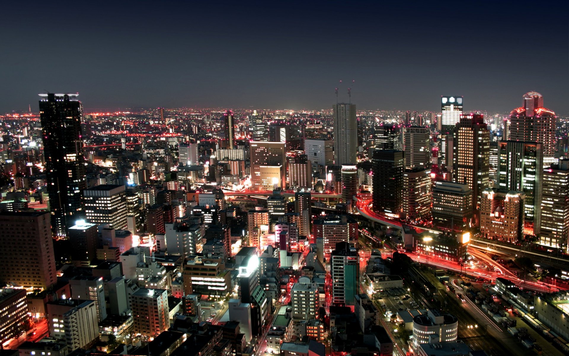 Nighttime cityscape of Bangkok featuring illuminated skyscrapers and busy streets, captured in HD for a vibrant PC desktop wallpaper background.