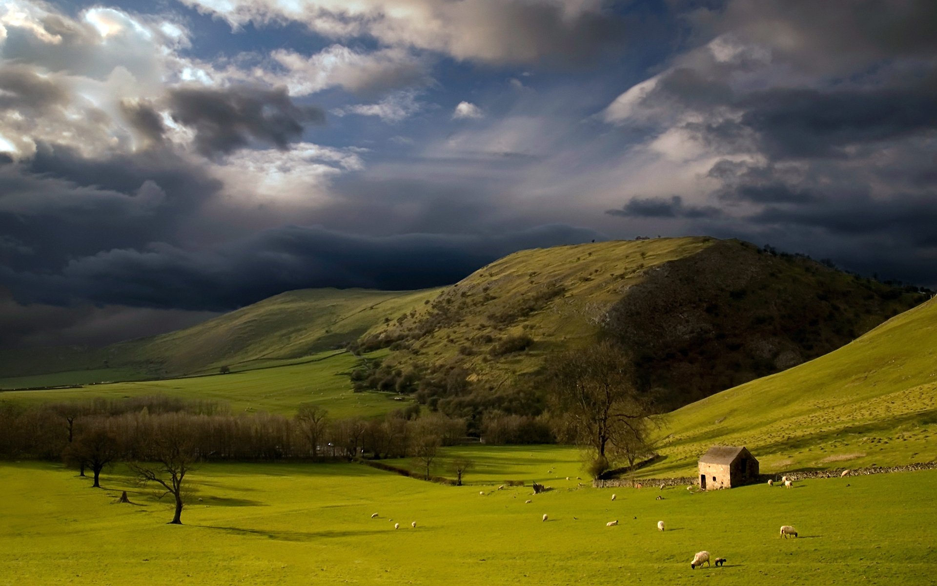 HD photography of a dramatic landscape featuring rolling green hills under a cloudy sky, captured as a serene PC desktop wallpaper and background.