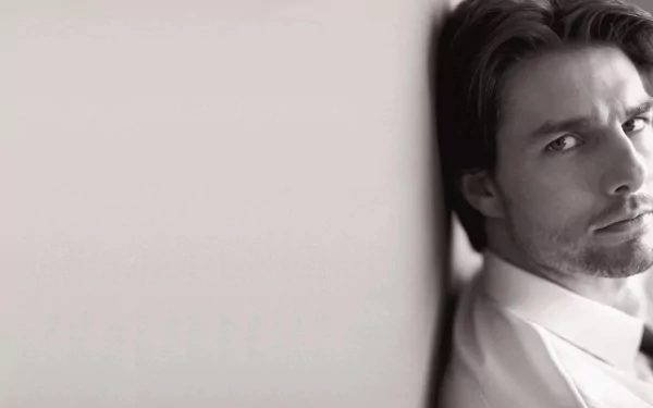 Black and white HD wallpaper featuring a close-up of celebrity Tom Cruise, capturing a thoughtful expression against a soft backdrop.
