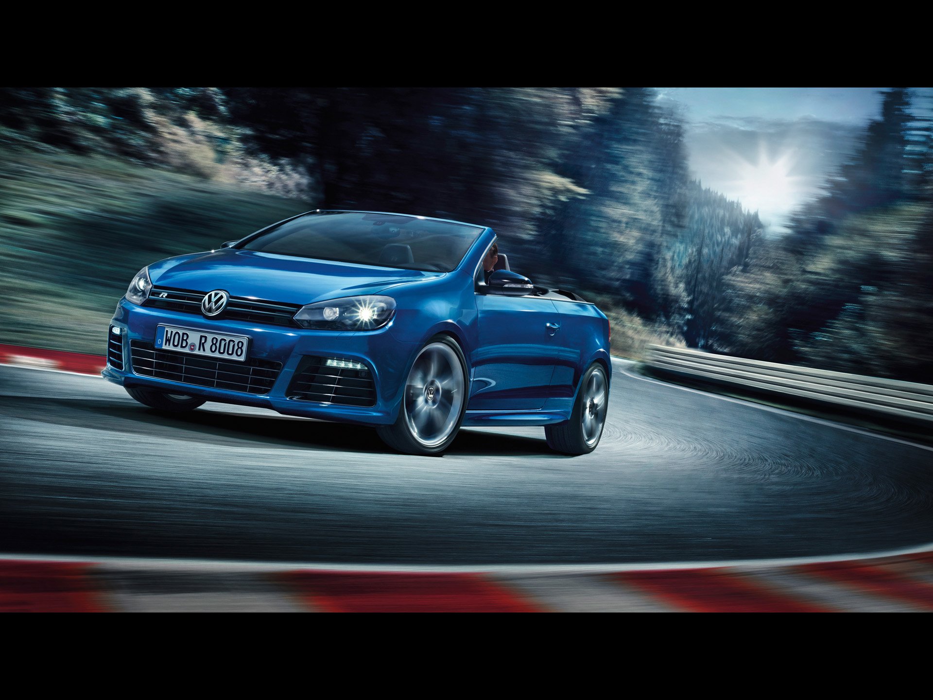 Blue 2013 Volkswagen Golf R cabriolet car racing a curving mountain road, dynamic HD PC desktop wallpaper showing the vehicle in motion.