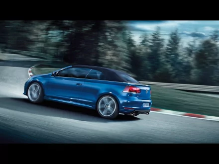 Blue 2013 Volkswagen Golf R Cabriolet speeding on a racetrack, captured in HD for a dynamic desktop wallpaper background.