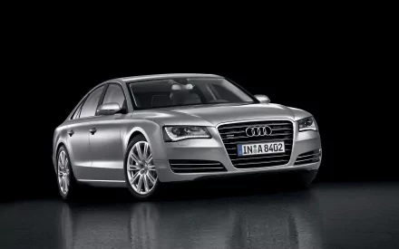 Silver Audi A8 sedan, three-quarter front view on a reflective black surface — HD PC desktop wallpaper and background.