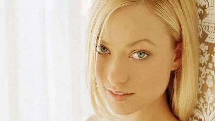 HD PC desktop wallpaper featuring celebrity Olivia Wilde with soft lighting and a close-up of her face and blonde hair.
