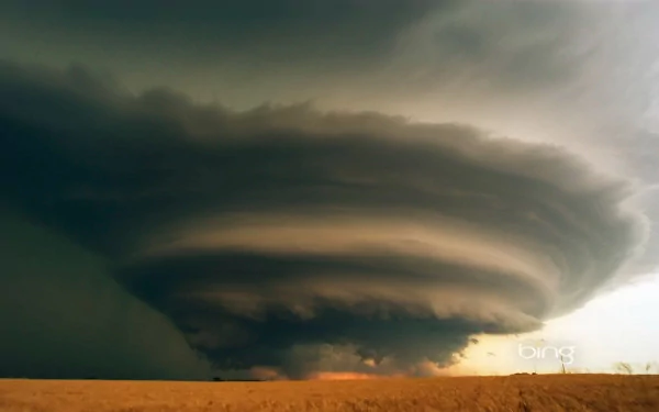 HD PC desktop wallpaper showing a dramatic, swirling storm cloud over a flat, open landscape in nature.