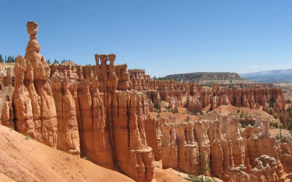 HD desktop wallpaper showcasing the striking red rock formations and hoodoos of Bryce Canyon National Park under a clear blue sky.