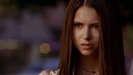 HD desktop wallpaper featuring celebrity Nina Dobrev with a serious expression, set against a softly blurred background.