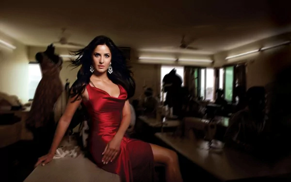 HD desktop wallpaper featuring Indian actress Katrina Kaif with long brown hair, striking blue eyes, wearing a red dress and elegant earrings in a dimly lit room.