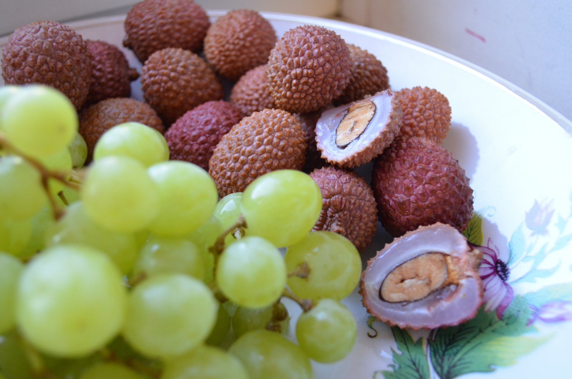 4K Ultra HD PC desktop wallpaper of fresh fruit — food: peeled and whole lychees with a cluster of green grapes in a white decorative bowl.