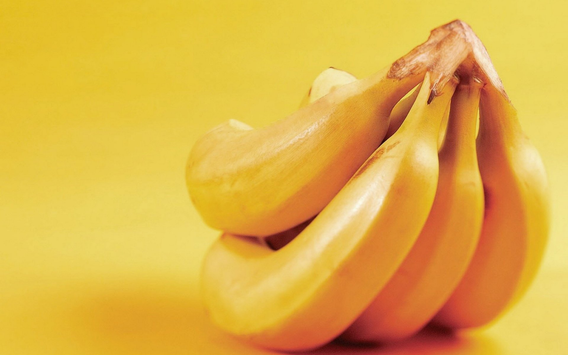 HD PC desktop wallpaper and background: close-up food photo of a ripe banana bunch against a warm yellow backdrop.