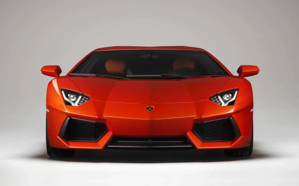 A striking orange Lamborghini Aventador LP 700-4 showcases its sleek design and powerful stance, making it a stunning HD desktop wallpaper and background.