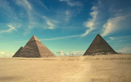 HD desktop wallpaper featuring two man-made pyramids under a vibrant blue sky with wispy clouds in a desert landscape.