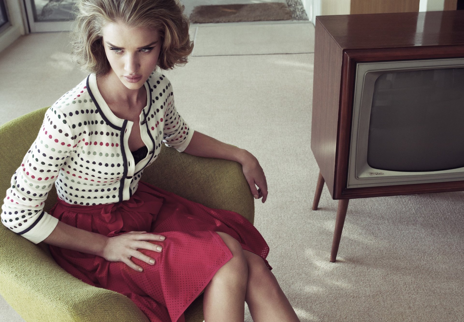 HD desktop wallpaper featuring celebrity Rosie Huntington-Whiteley sitting on a green chair in a retro-styled room with a vintage television set.