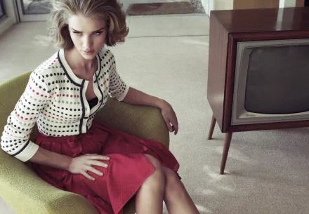 HD desktop wallpaper featuring celebrity Rosie Huntington-Whiteley sitting on a green chair in a retro-styled room with a vintage television set.