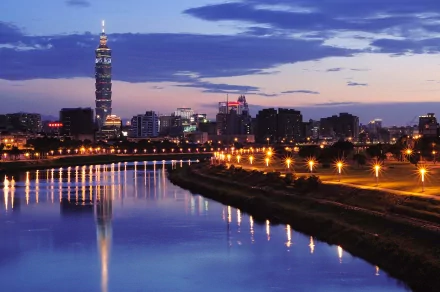 HD desktop wallpaper showcasing Taipei's skyline at dusk with illuminated buildings and Taipei 101 tower reflecting on the river.