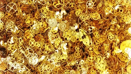 HD desktop wallpaper featuring a close-up view of numerous golden watch gears and components, showcasing intricate man-made mechanical details.