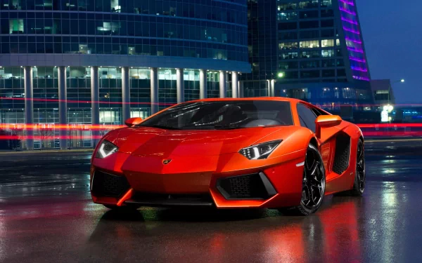 Vibrant Lamborghini Aventador LP 700-4 parked in a modern urban setting at night, showcasing its sleek design against illuminated buildings. An ideal HD desktop wallpaper.