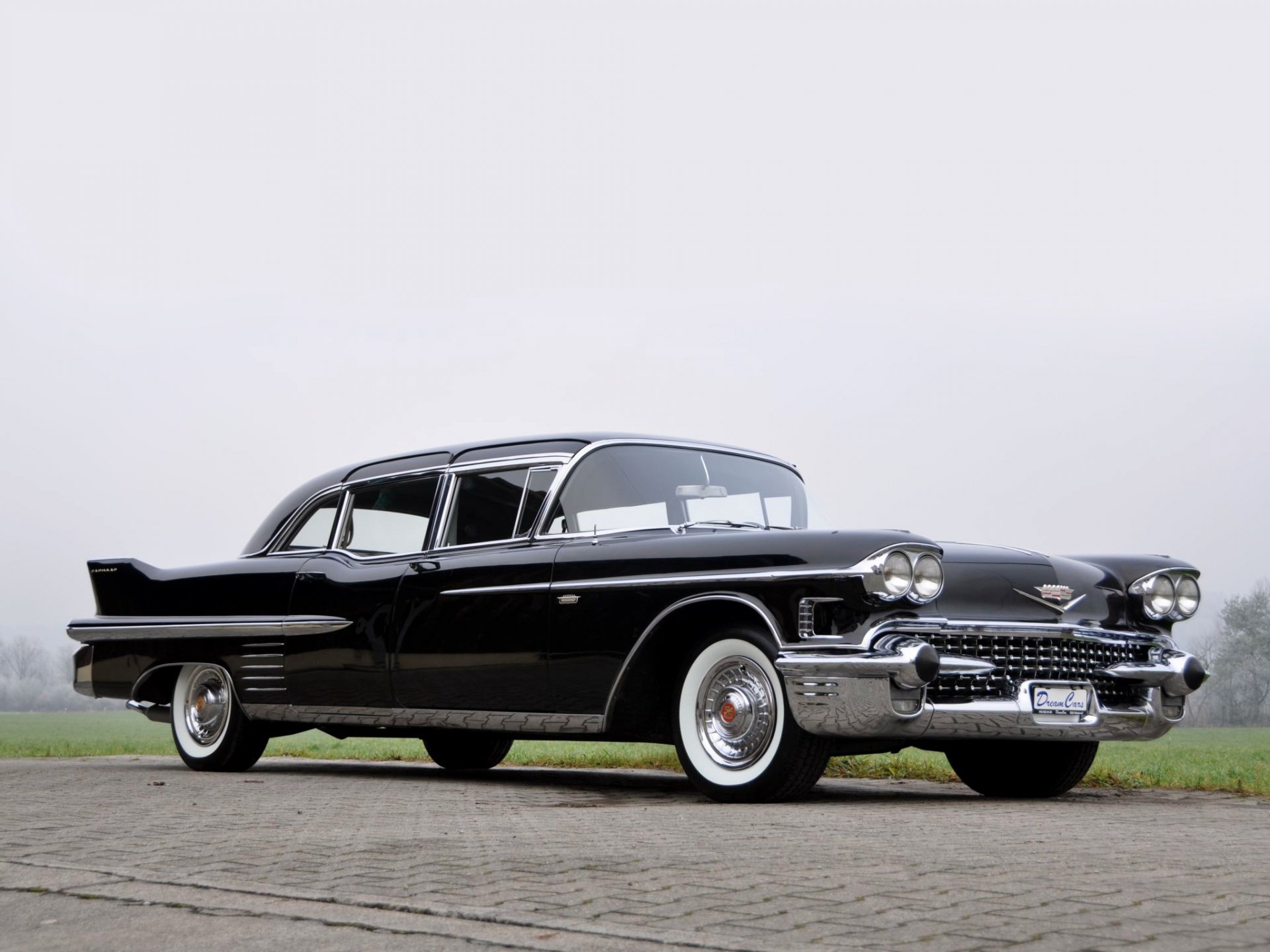 A sleek black 1958 Cadillac Fleetwood Limousine parked on a paved surface, featured as an HD PC desktop wallpaper and background.