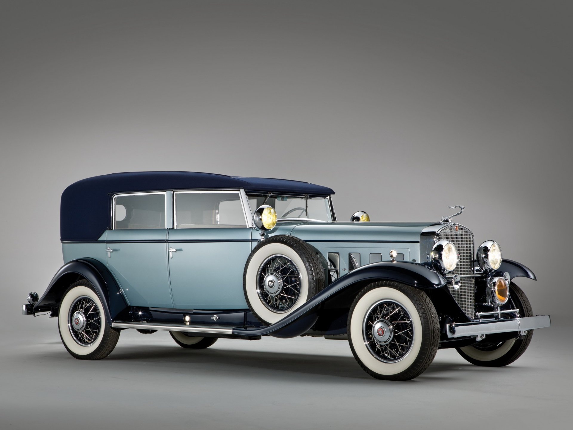 Classic Cadillac V16 vehicle showcased in a high-definition PC desktop wallpaper, featuring its elegant vintage design and luxurious detailing against a neutral background.