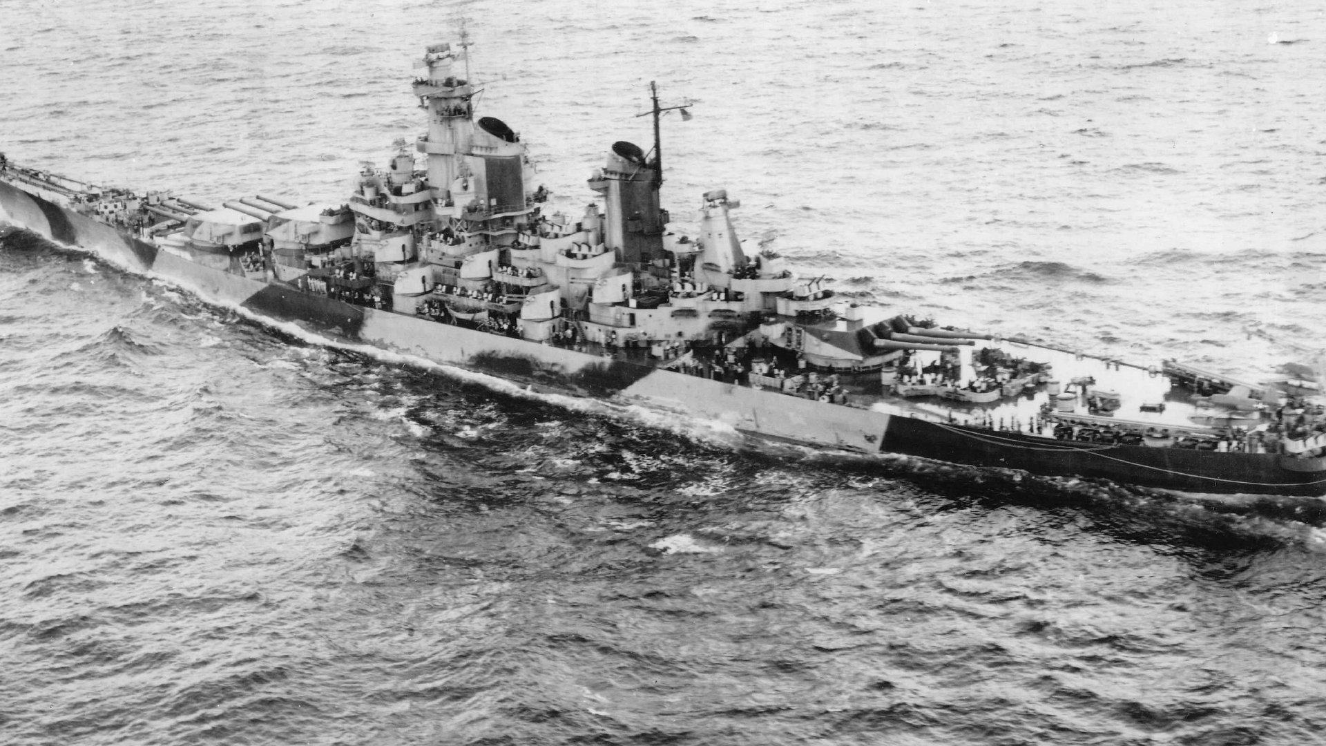 HD desktop wallpaper of the USS Iowa (BB-61), a powerful military battleship and warship sailing through the ocean.