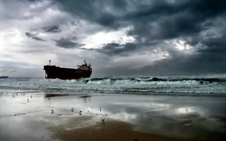 A dramatic view of a tanker vessel navigating rough seas under ominous clouds, captured in high definition as a stunning desktop wallpaper and background.