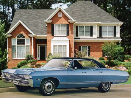 HD PC desktop wallpaper featuring a classic Chevrolet Caprice parked in front of a two-story brick house with white trim and a well-kept garden.