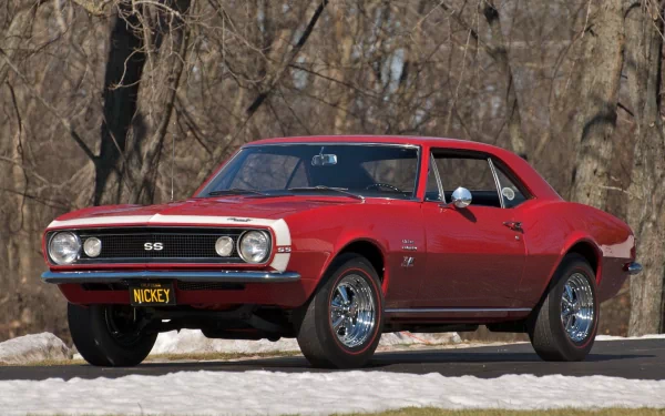 A red Chevrolet Camaro SS classic muscle car parked outdoors with bare trees in the background, captured in HD for a PC desktop wallpaper and background.