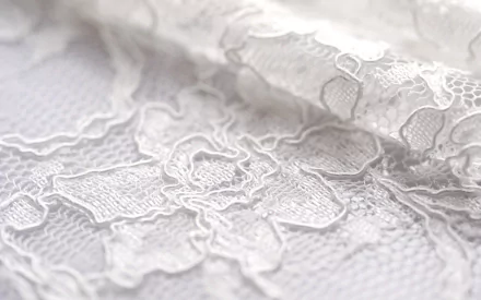 Abstract close-up of delicate white lace fabric, showcasing intricate patterns and textures, designed as an HD PC desktop wallpaper and background.
