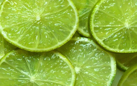 Close-up HD desktop wallpaper of fresh lime slices with dewy texture, highlighting vibrant green hues and juicy food details.