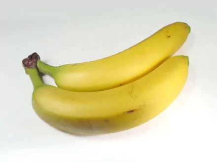 HD PC desktop wallpaper of two ripe yellow bananas on a clean white background, a food-themed background image.
