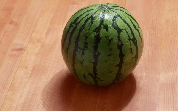 HD desktop wallpaper featuring a fresh whole watermelon on a wooden surface, highlighting vibrant green stripes and smooth texture.