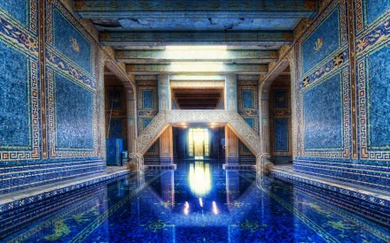 HD desktop wallpaper of an ornate man-made indoor pool with intricate blue tilework and a reflective water surface inside a grand architectural setting.