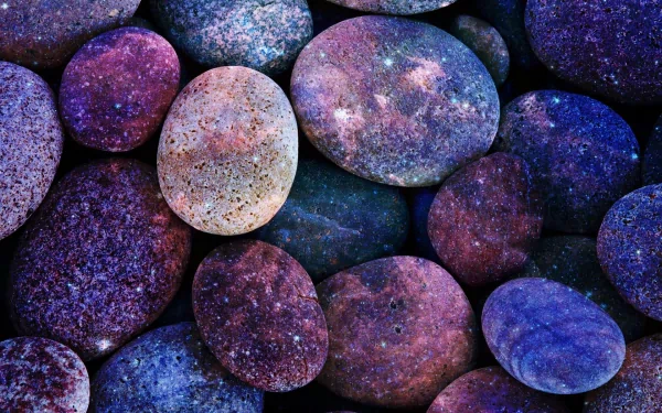 HD desktop wallpaper showcasing a close-up of smooth, colorful stones in shades of purple and blue, highlighting natural textures and tones.