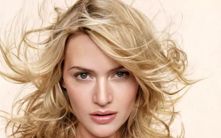 A stunning HD desktop wallpaper of celebrity Kate Winslet, featuring her with flowing blonde hair and a captivating gaze against a soft, neutral background.