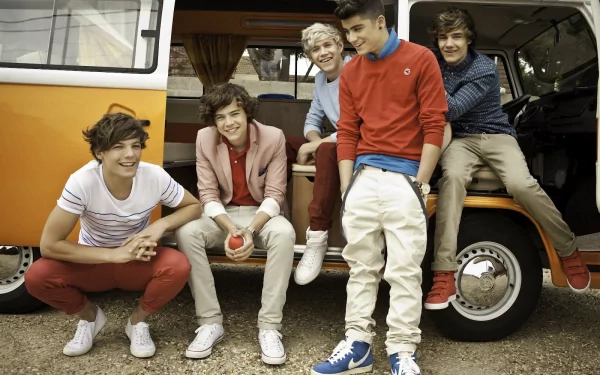 HD wallpaper image of One Direction sitting and standing outside an orange van, smiling and enjoying a casual moment. Tags: music, One Direction, desktop background.