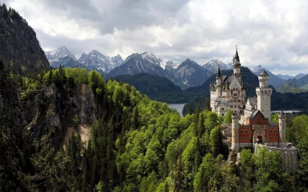 Neuschwanstein Castle, nestled among lush greenery and majestic mountains, offers a breathtaking view, making it a stunning HD desktop wallpaper and background.