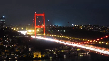 2K Quad HD PC desktop wallpaper: night view of the man-made Bosphorus Bridge illuminated with light trails stretching across the city.
