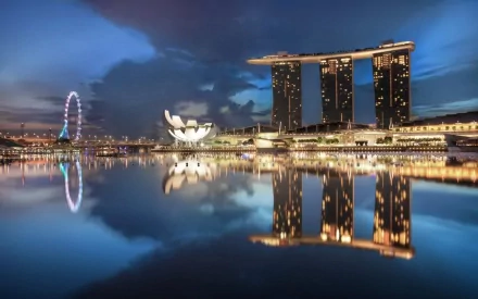 HD desktop wallpaper showcasing Singapore’s iconic man-made skyline with Marina Bay Sands, the ArtScience Museum, and the Singapore Flyer reflected in calm water at dusk.